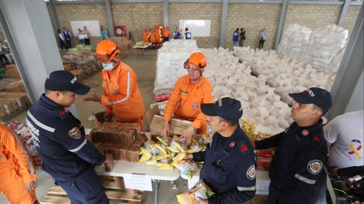 Autoridades organizan este viernes el cargamento con la ayuda humanitaria para Venezuela en un centro de acopio.