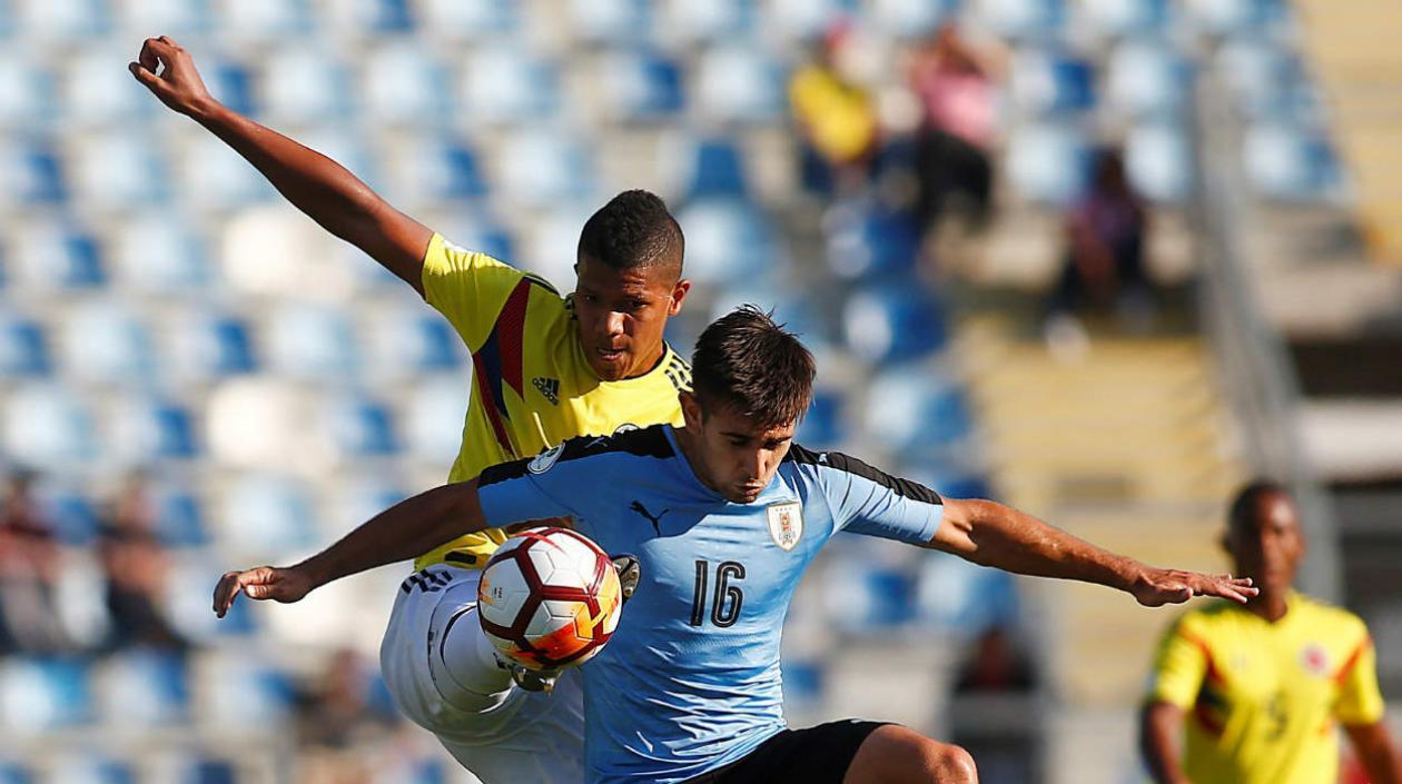 Jaime Alvarado marca a un jugador de la Selección de Uruguay. 