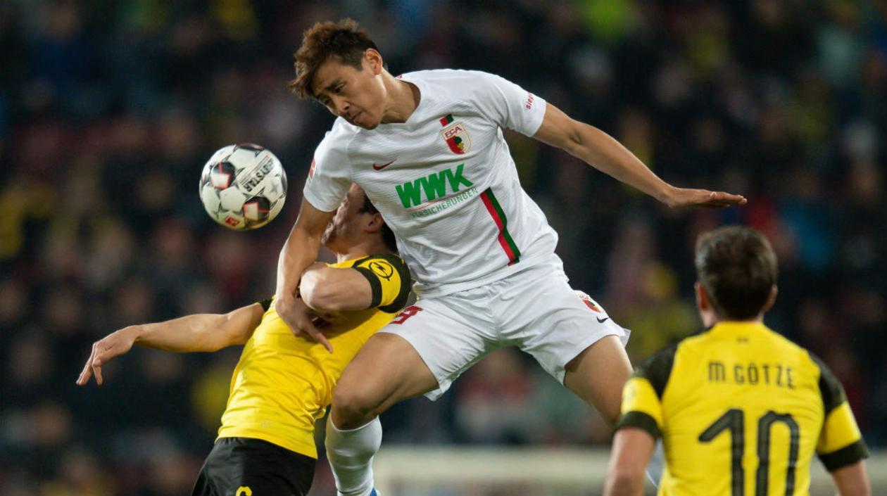 Ji Dong-Won disputa la pelota con dos jugadores del Dortmund. 
