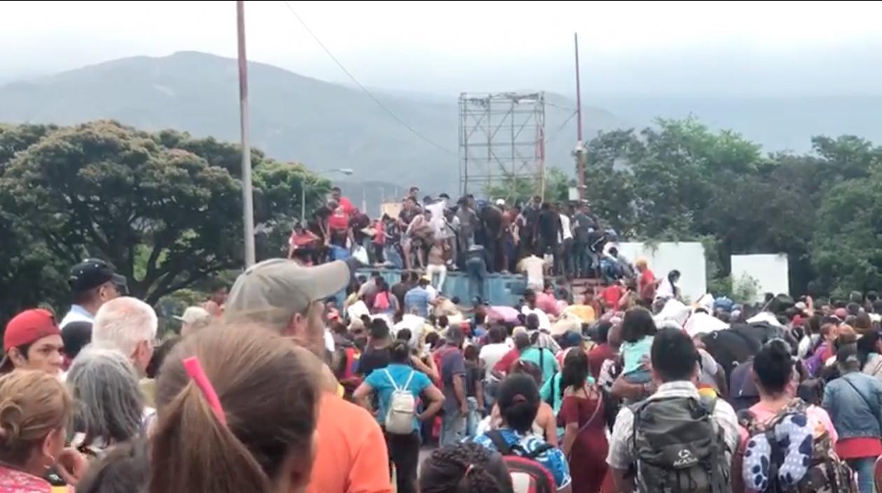 Numerosas personas superando los contenedores dispuestos por el gobierno venezolano en la frontera.