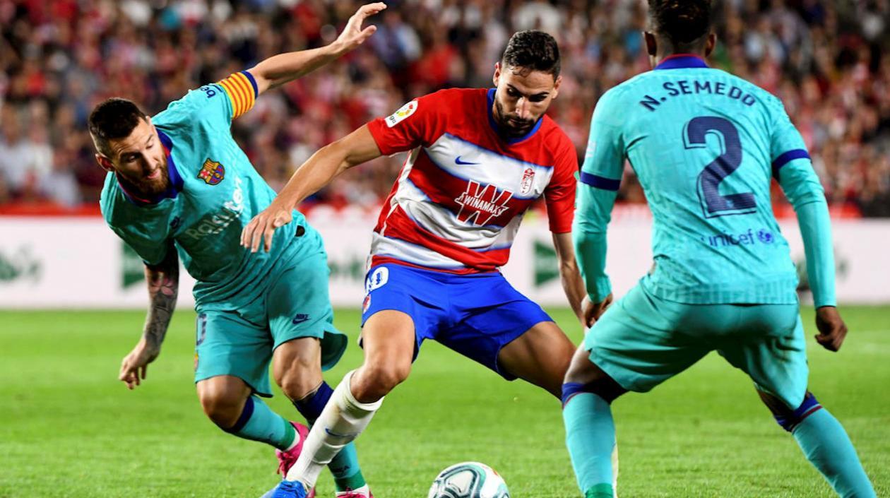 El delantero argentino del Barcelona Lio Messi lucha con Antonio Puertas.