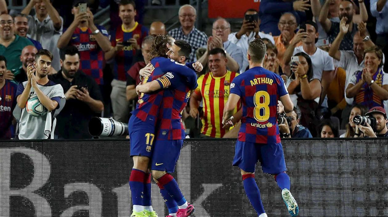 Antoine Griezmann se abraza con Lionel Messi y Arthur Melo los observa. 