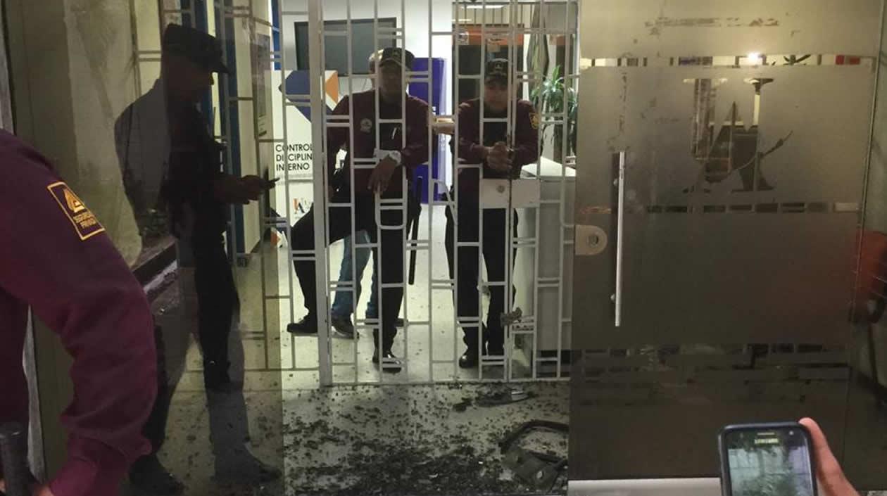 Vidrios reventados en la puerta del edificio de Rectoría, donde los vigilantes fueron atacados con bombas incendiarias.