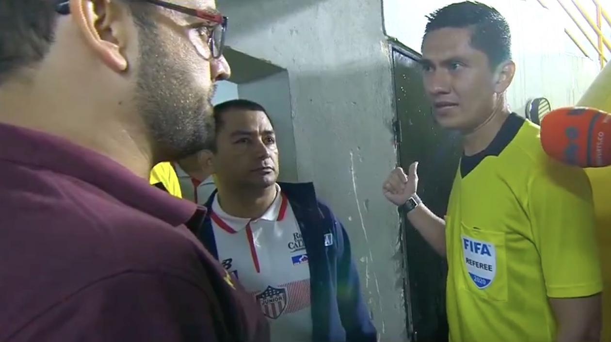 El árbitro Mario Herrera comunicándole a los delegados de los equipos la suspensión del partido.