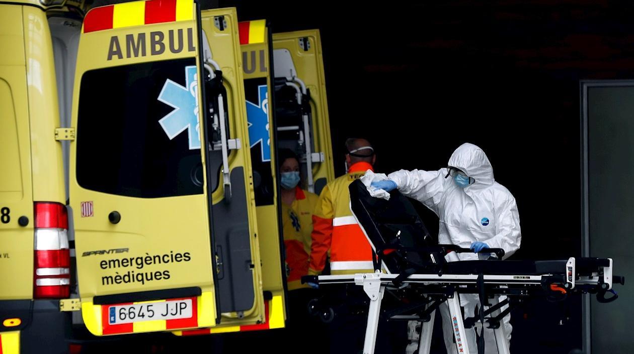 Un técnico sanitario desinfecta la camilla de una ambulancia en la entrada de urgencias del Hospital de Bellvitge.
