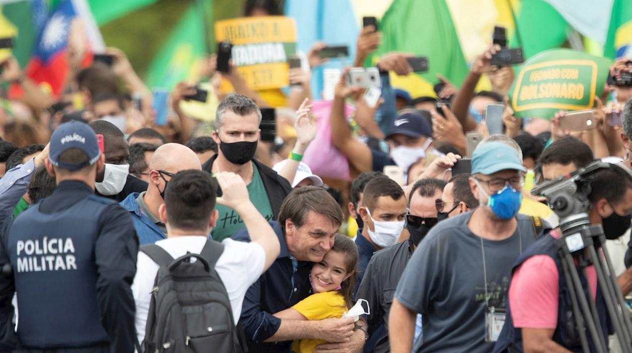 El presidente de Brasil, Jair Bolsonaro, saluda a una niña este domingo, en Brasilia (Brasil).