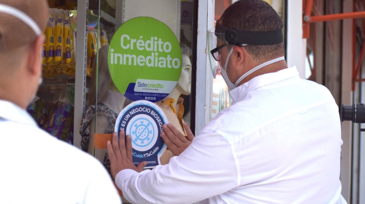 El Alcalde Roberto Celedón colocando el sello de bioseguridad en uno de los negocios.