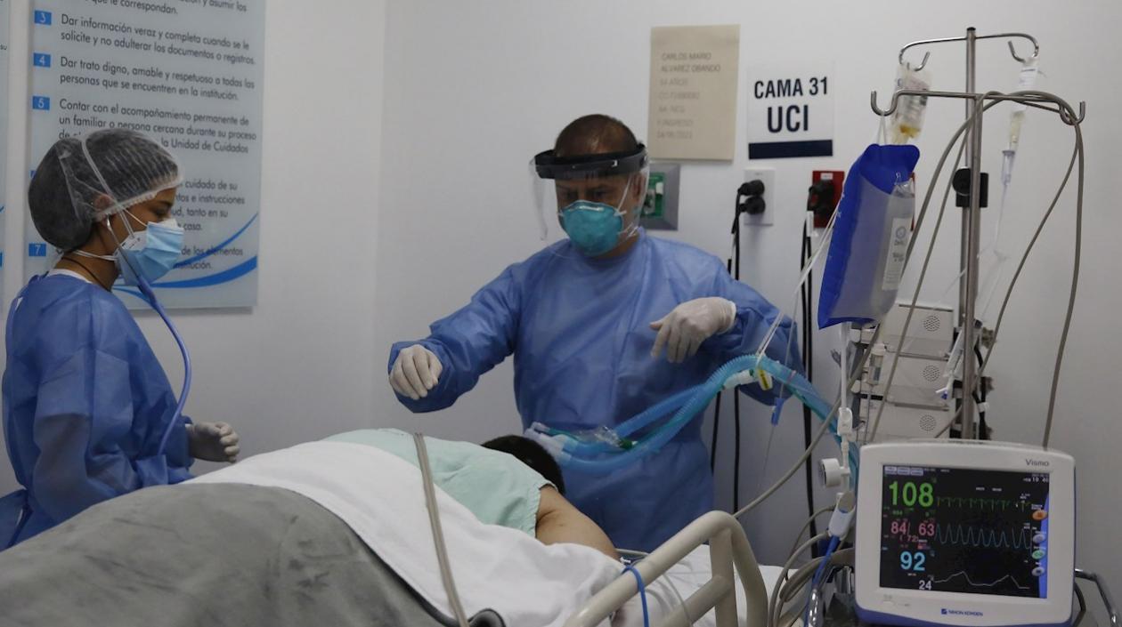 Empleados de la salud atienden a un paciente en la unidad de cuidados intensivos para enfermos de Covid-19 en la Clínica CES, en Medellín.