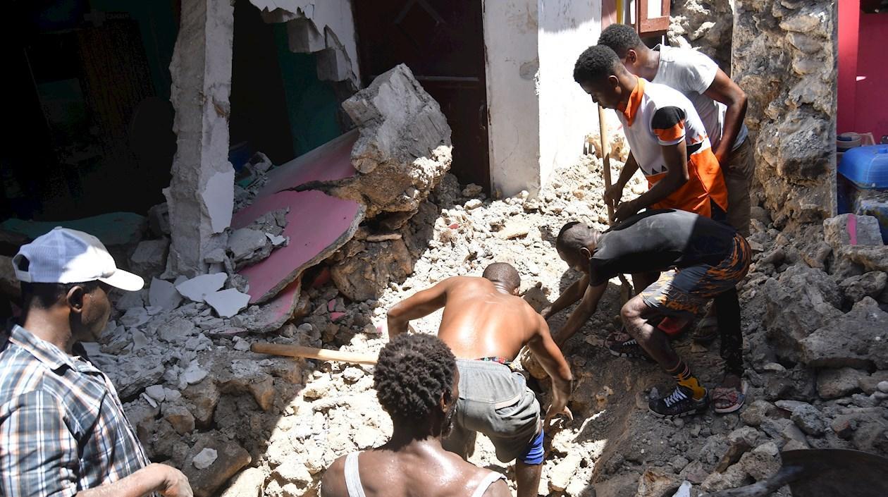 Un grupo de personas remueve escombros tras el terremoto en Haití.