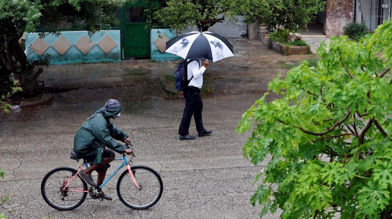 Dos personas se protegen de la lluvia hoy, en La Habana (Cuba).