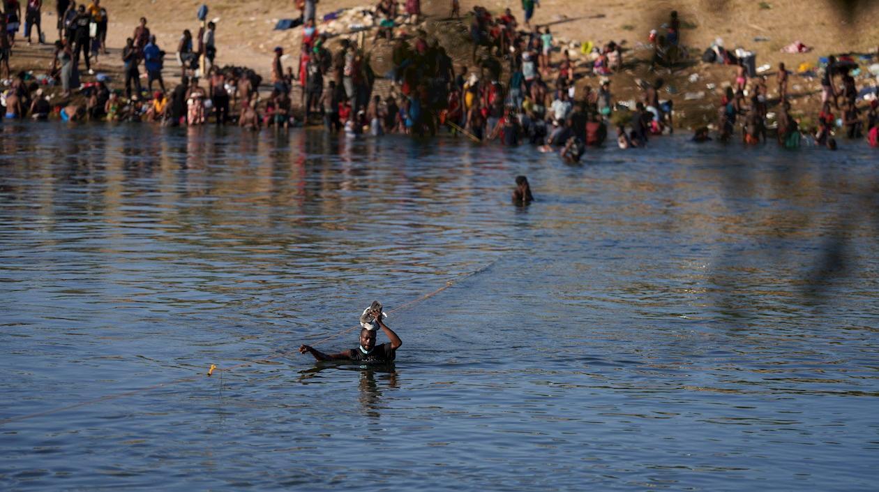 Un migrante cruza el río Bravo entre Estados Unidos y México, cerca de Del Río, Texas.