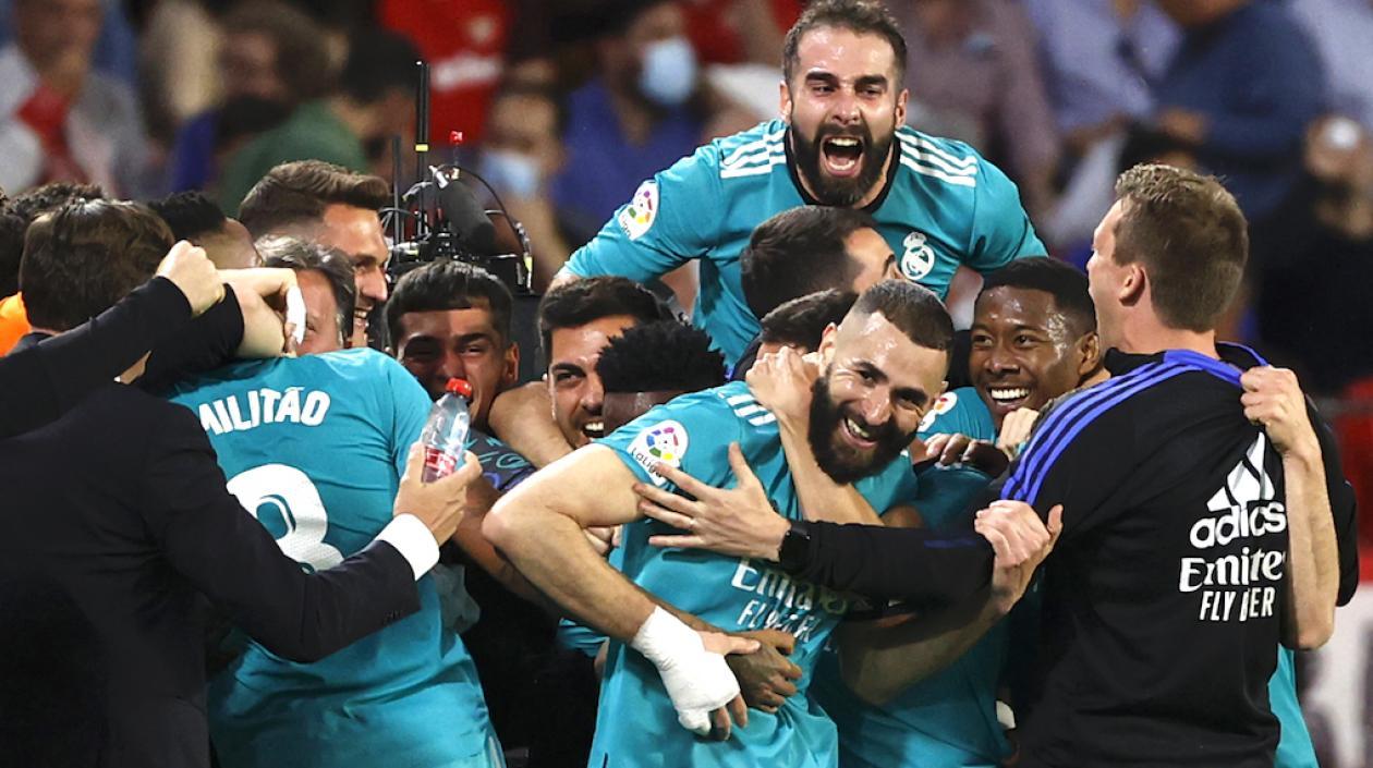 Karim Benzema felicitado por sus compañeros tras anotar ante el Sevilla.