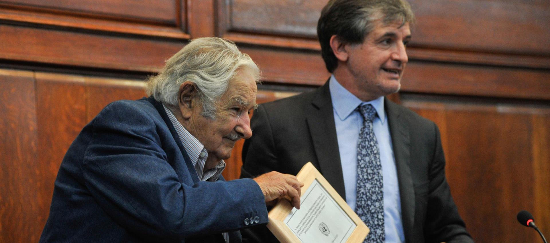 El expresidente de Uruguay José Mujica recibe un reconocimiento de manos del jefe de reincorporación de la Misión de Verificación de las Naciones Unidas en Colombia, Alessandro Preti