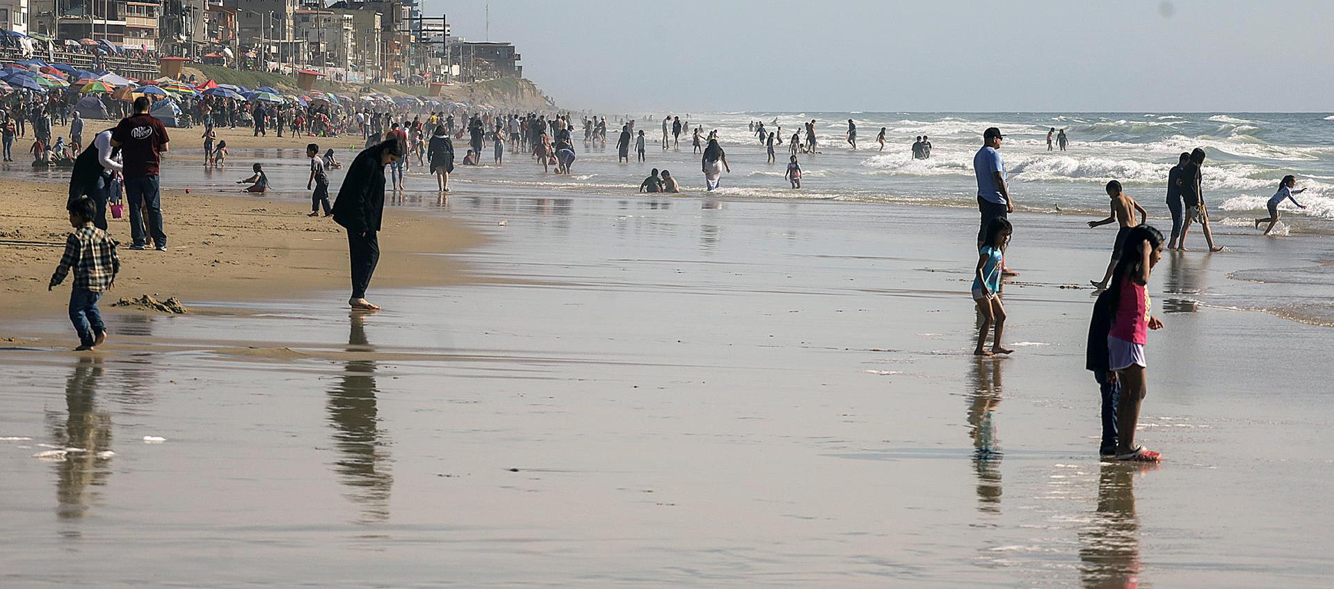 Visitantes disfrutan de la playa pese a las restricciones por la alta contaminación, en la ciudad de Tijuana.