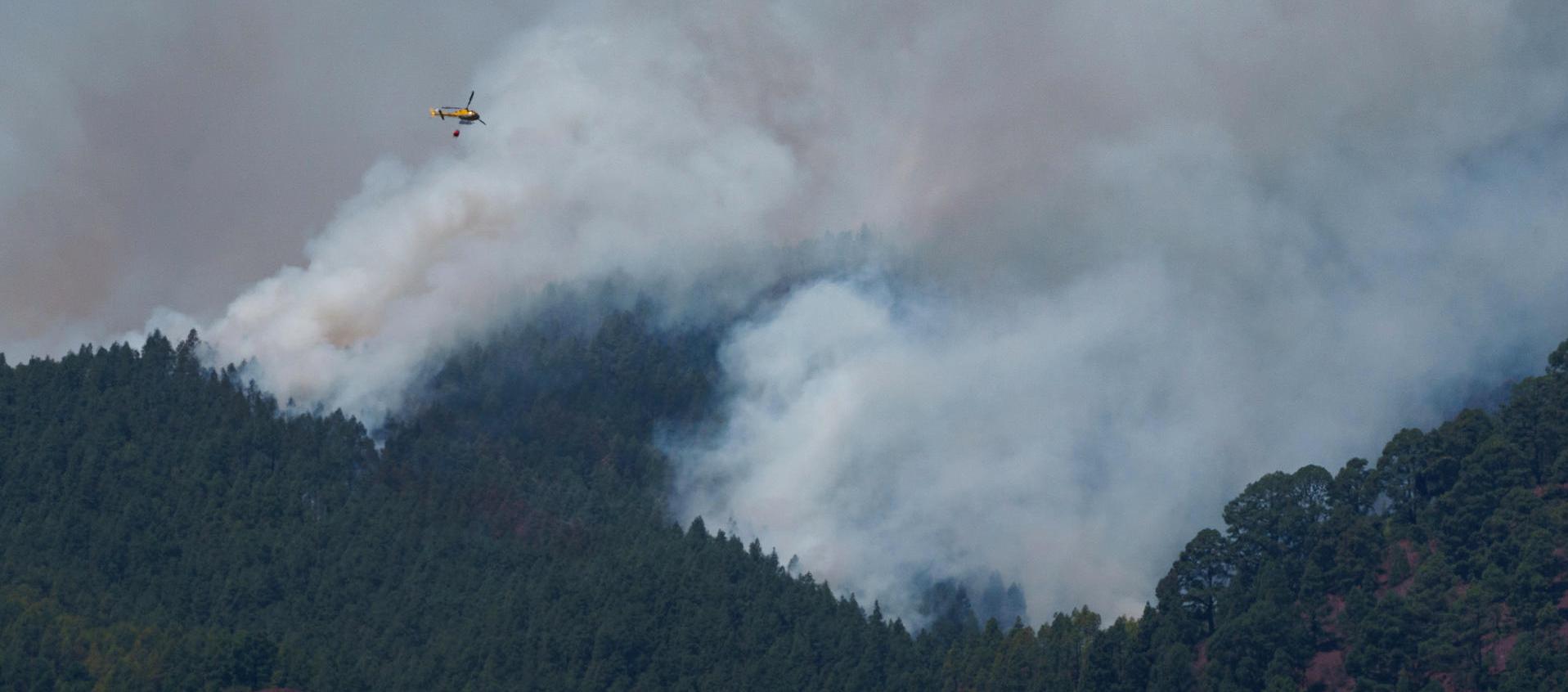 Un helicóptero trabaja en la extinción del incendio forestal en los altos de Güímar.