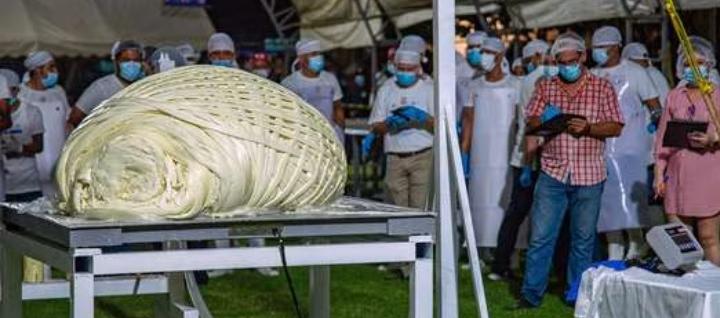 Miembros del Comité del Récord Guinness observan la bola de queso de 558 kilos