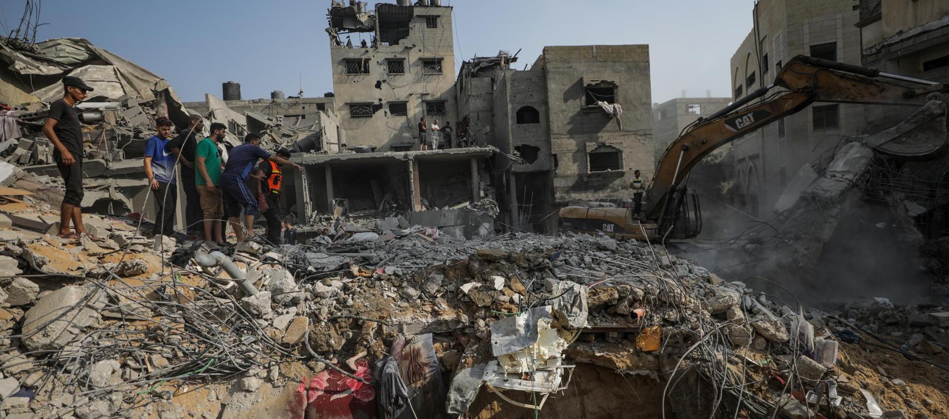 Palestinos buscan entre los escombros de la casa de la familia Al Faseih destruida tras un ataque aéreo.