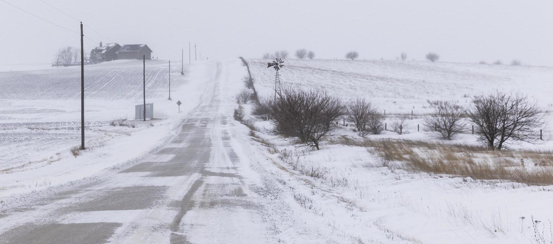 Vista de una calle cubierta con nieve tras una tormenta, en Adair County, Iowa
