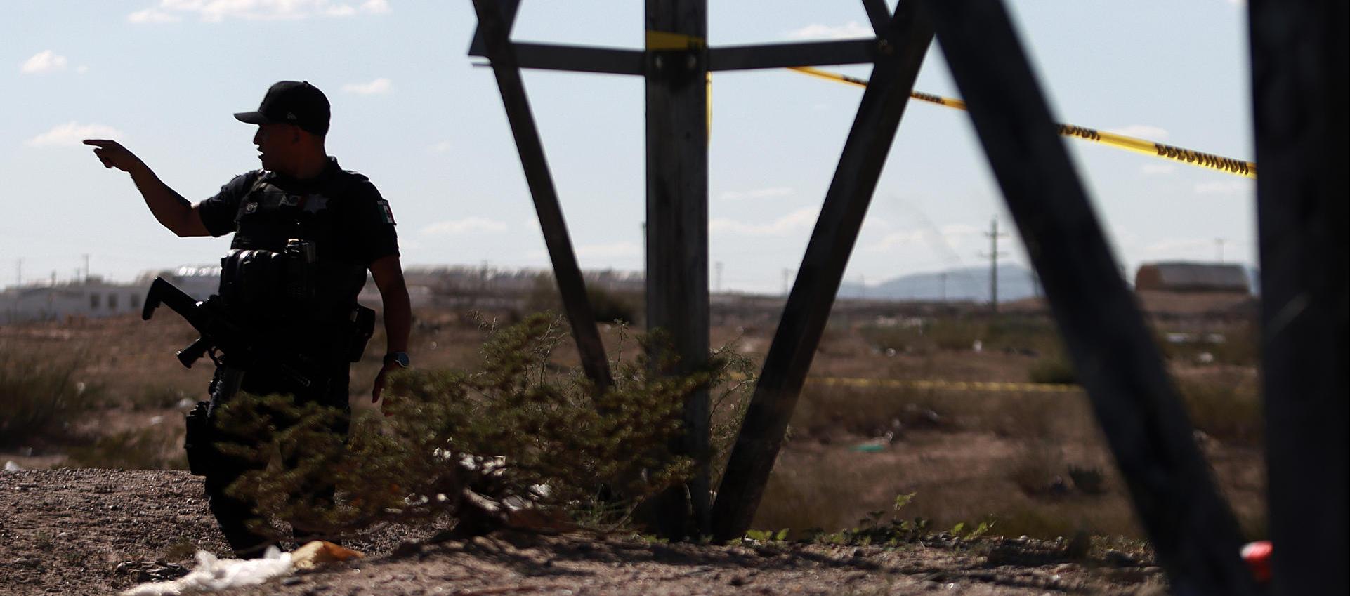 Un policía monta guardia en la fosa común hallada en zona rural de Ciudad Juárez