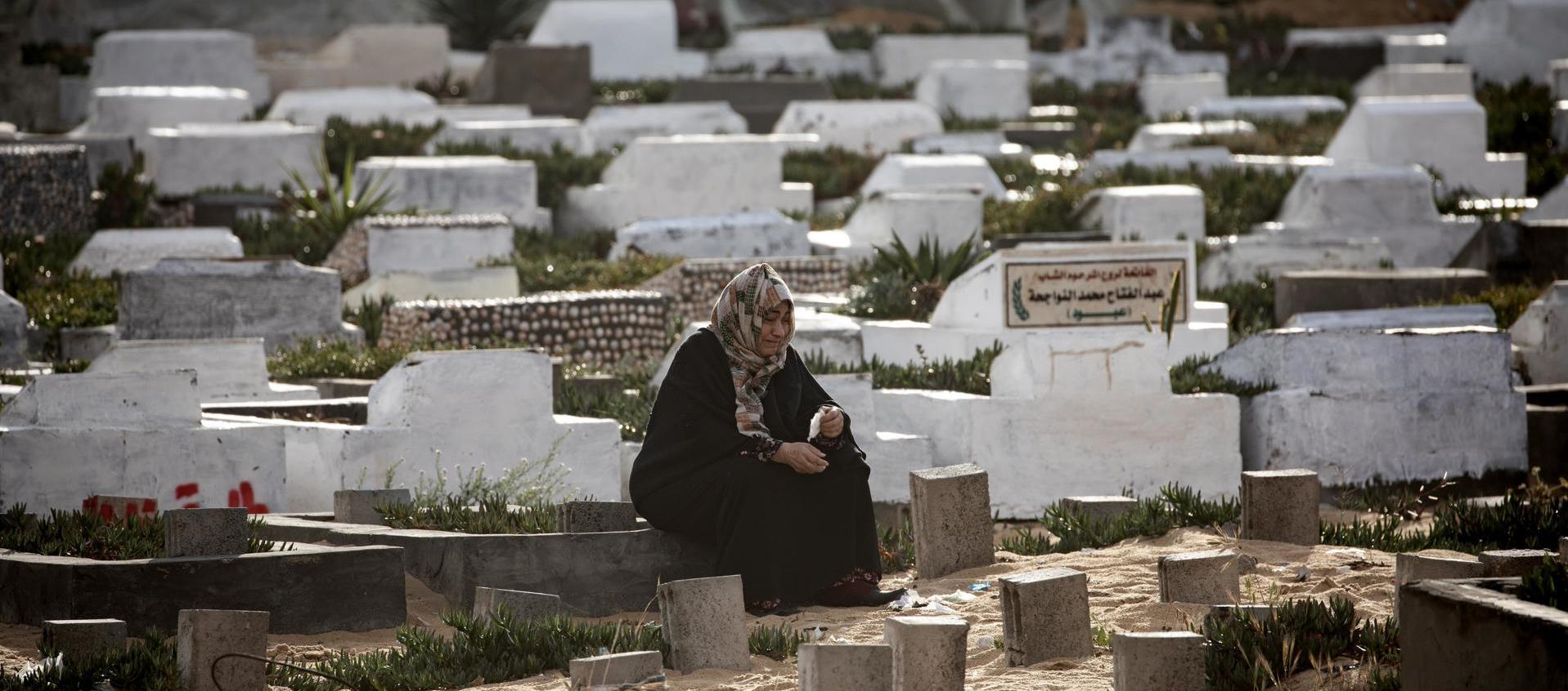 Una palestina visitando la tumba de un ser querido.