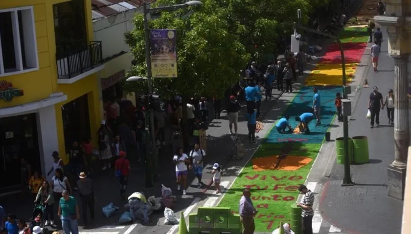  Voluntarios guatemaltecos participan en la elaboración de una alfombra de serrín.