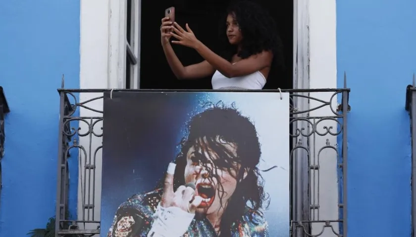 Una joven se hace una foto en un balcón, donde se grabo el video del cantante 