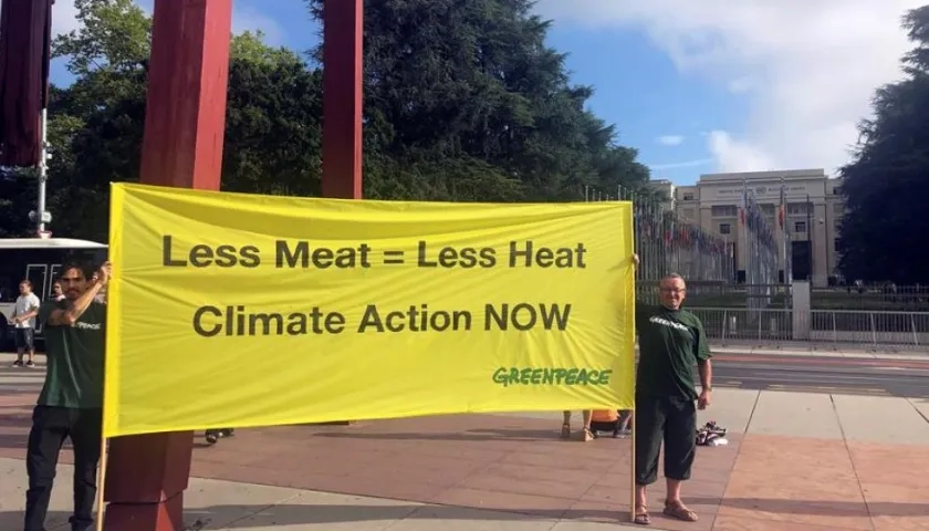 Dos miembros de Greenpeace muestran una pancarta con el mensaje 'Menos carne es igual a menos calor. Acción climática ahora'.