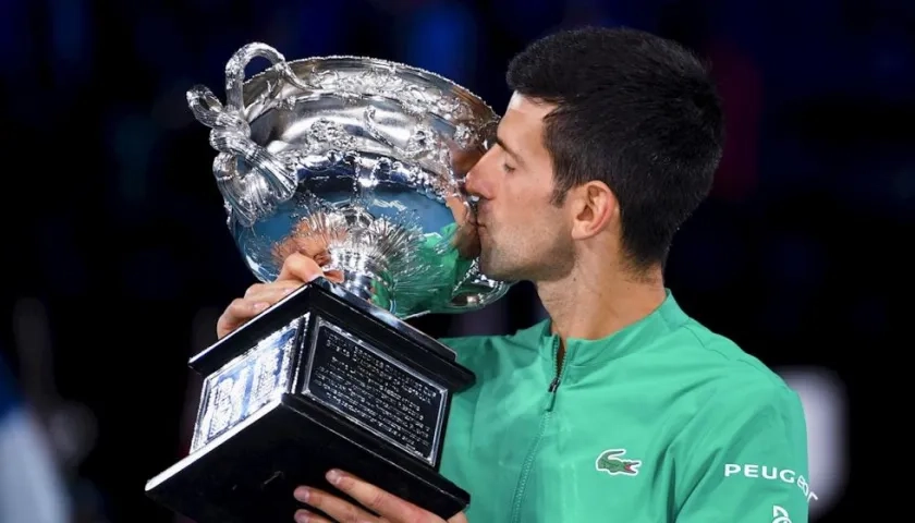 El serbio Novak Djokovic besa el trofeo al ganar el Abierto de Australia. 