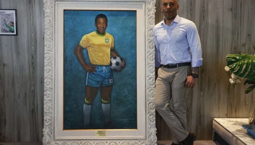 Edinho junto a un retrato de su padre en el Museo Pelé.