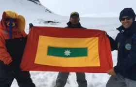 El suboficial primero Joel Calzado junto a Pedro Pallares y la bandera de Barranquilla en la Antártida.
