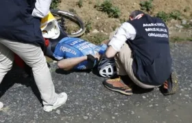 Michael Goolaerts desplomado al lado de su bicicleta. 