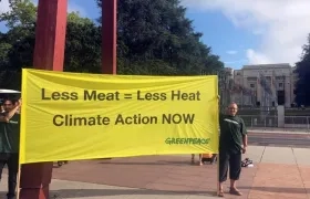Dos miembros de Greenpeace muestran una pancarta con el mensaje 'Menos carne es igual a menos calor. Acción climática ahora'.