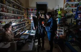 Personas compran productos en una tienda durante un apagón en Leópolis, en Ucrania.