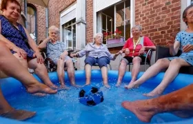 Mujeres se refrescan con los pies metidos en una piscina de plástico en una residencia de ancianos en Chatelet, Bélgica, donde se registran temperaturas de hasta 40 grados. 