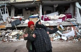 Dos mujeres lloran junto a un edificio derrumbado tras el gran terremoto en el distrito de Elbistan de Kahramanmaras.