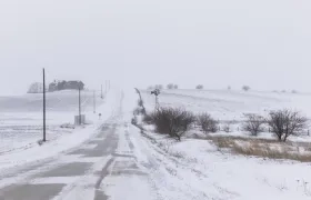 Vista de una calle cubierta con nieve tras una tormenta, en Adair County, Iowa