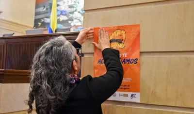 La senadora María José Pizarro pega un cartel en contra del abuso sexual en la sede del Congreso.