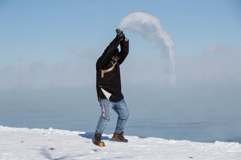 Un hombre lanza agua caliente al gélido aire, este miércoles cerca del Lago Michigan en Chicago, Illinois (Estados Unidos).