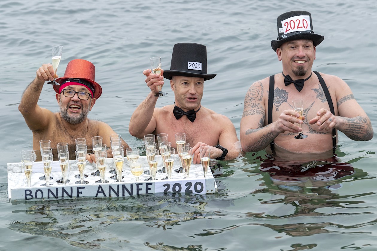 Personas celebraron la llegada del nuevo año con champaña en el frío lago de Ginebra (Suiza).