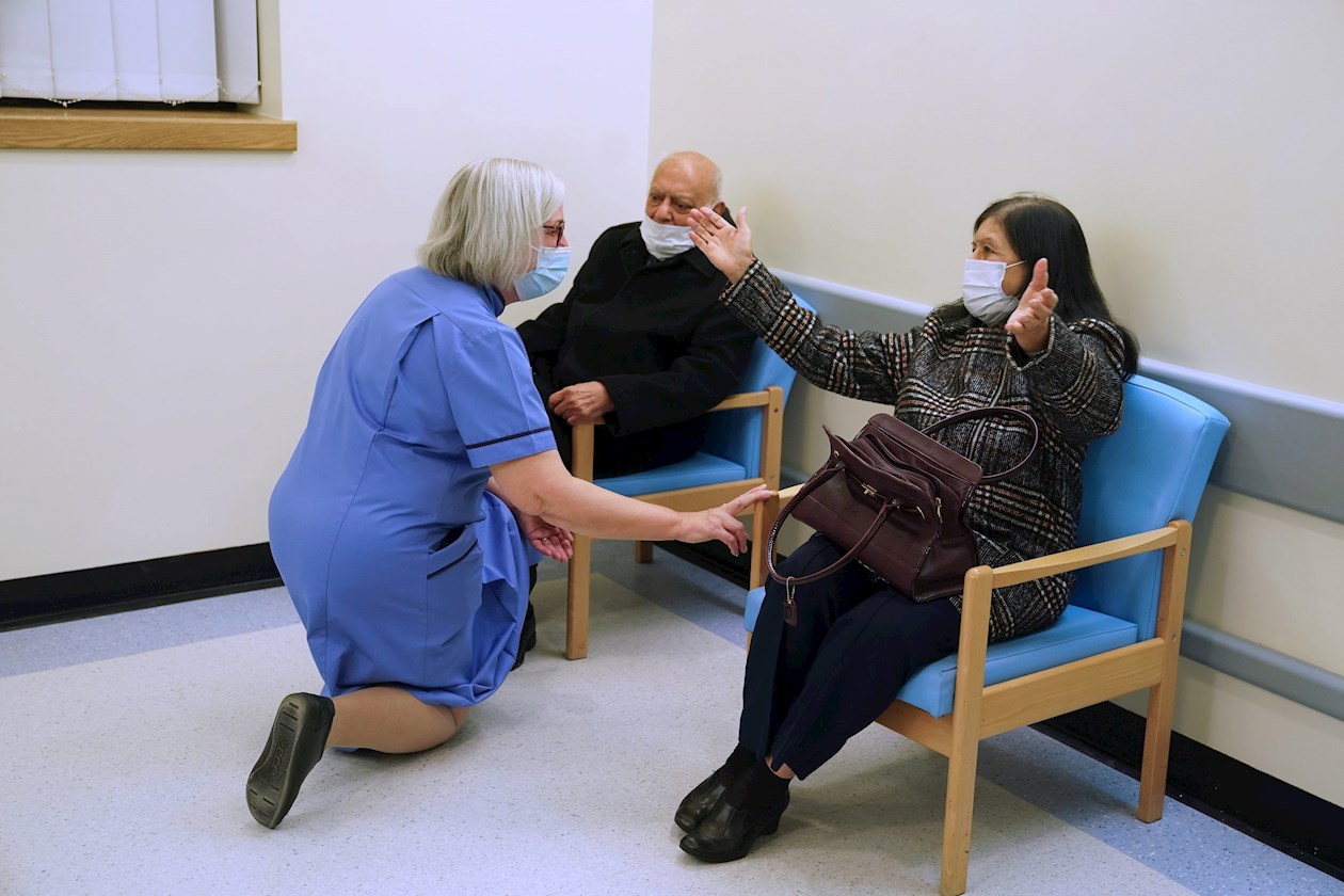 La enfermera jubilada Suzanne Medows (izquierda) habla con Hari Shukla (C), de 87 años, y su esposa Ranjan antes de recibir la primera de las dos vacunas Pfizer / BioNTech Covid-19 en Royal Victoria Infirmary en Newcastle, Gran Bretaña.