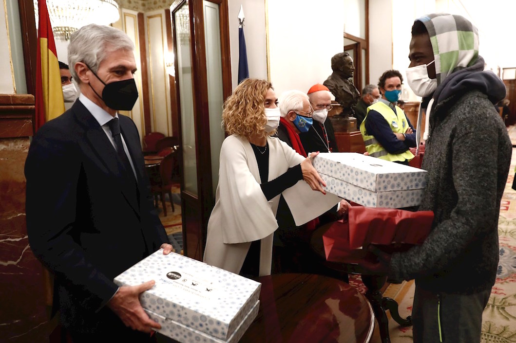 La presidenta de la Cámara Baja Meritxell Batet y el secretario del Congreso de los Diputados Adolfo Suárez Yllana reparten cajas con comida acompañados por el padre Ángel y el cardenal Osorio, en Madrid (España).