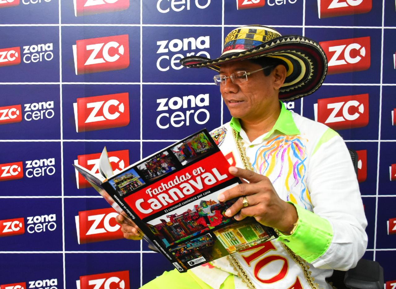 El Rey Momo Alcides Romero enseñando su libro 'Fachadas en Carnaval'.