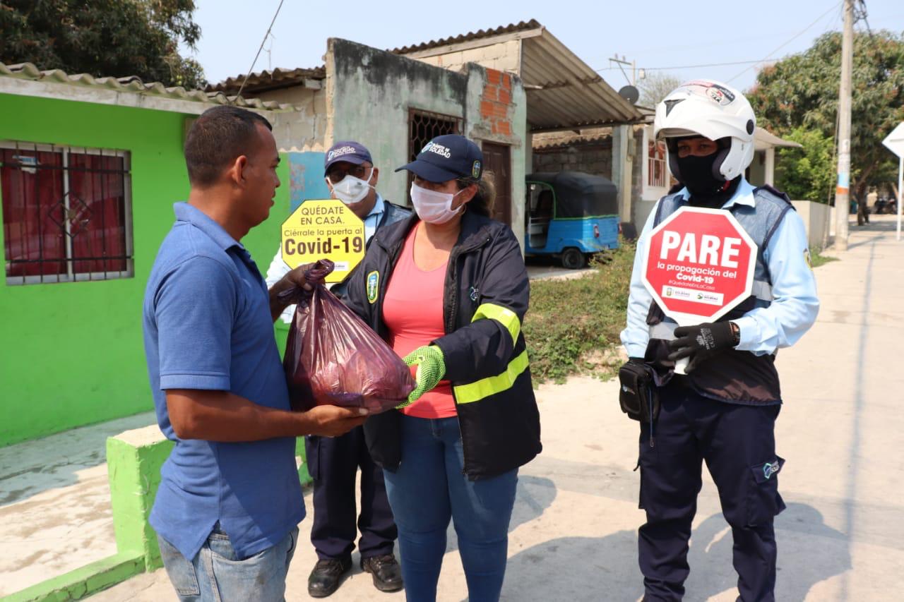 Directora del Tránsito en Soledad, Yomaira Solano y varios agentes, entregando las ayudas alimentarias.