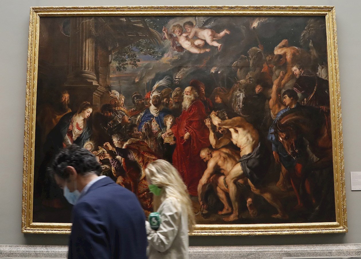 Dos personas pasan ante la obra de Rubens "La adoración de los Reyes Magos" durante la presentación de "Reencuentro".