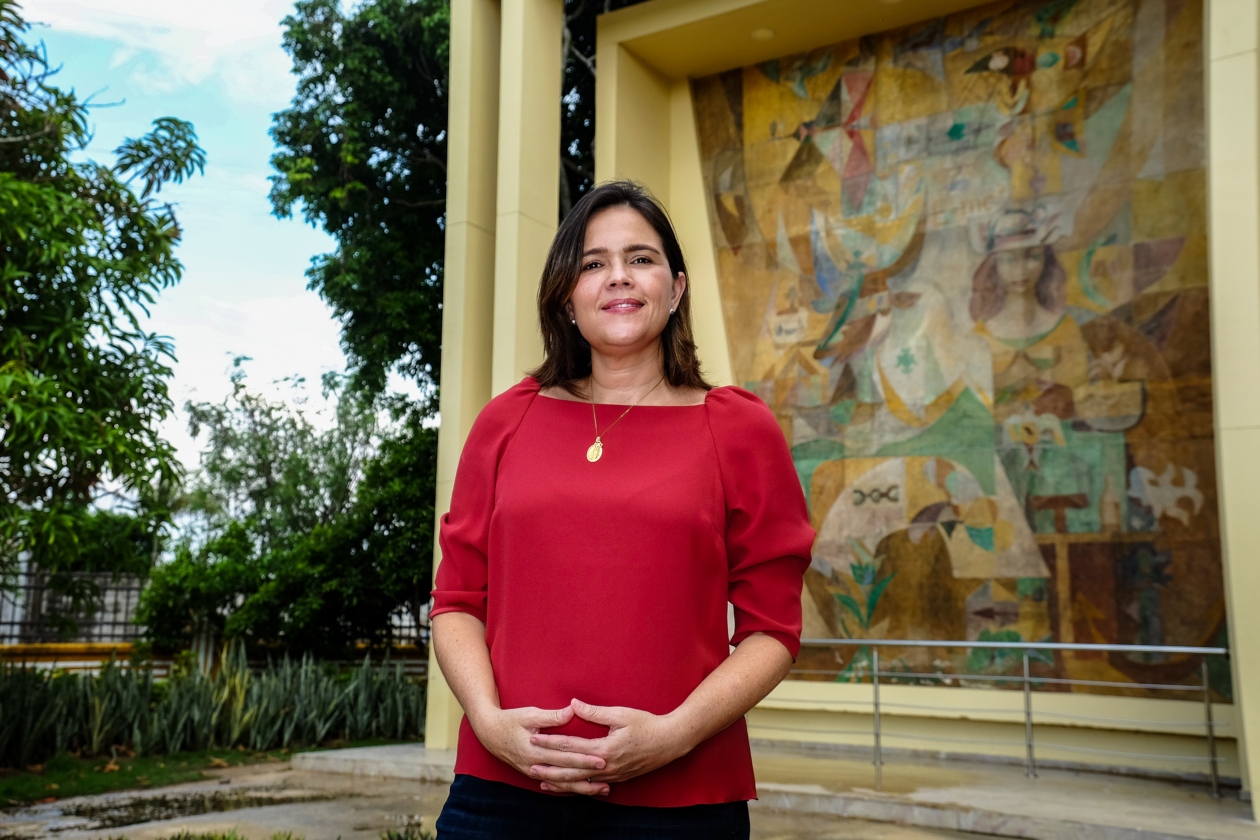 La secretaria de Cultura, Patrimonio y Turismo del Distrito, María Teresa Fernández. En el fondo, la obra Simbiología de Barranquilla.