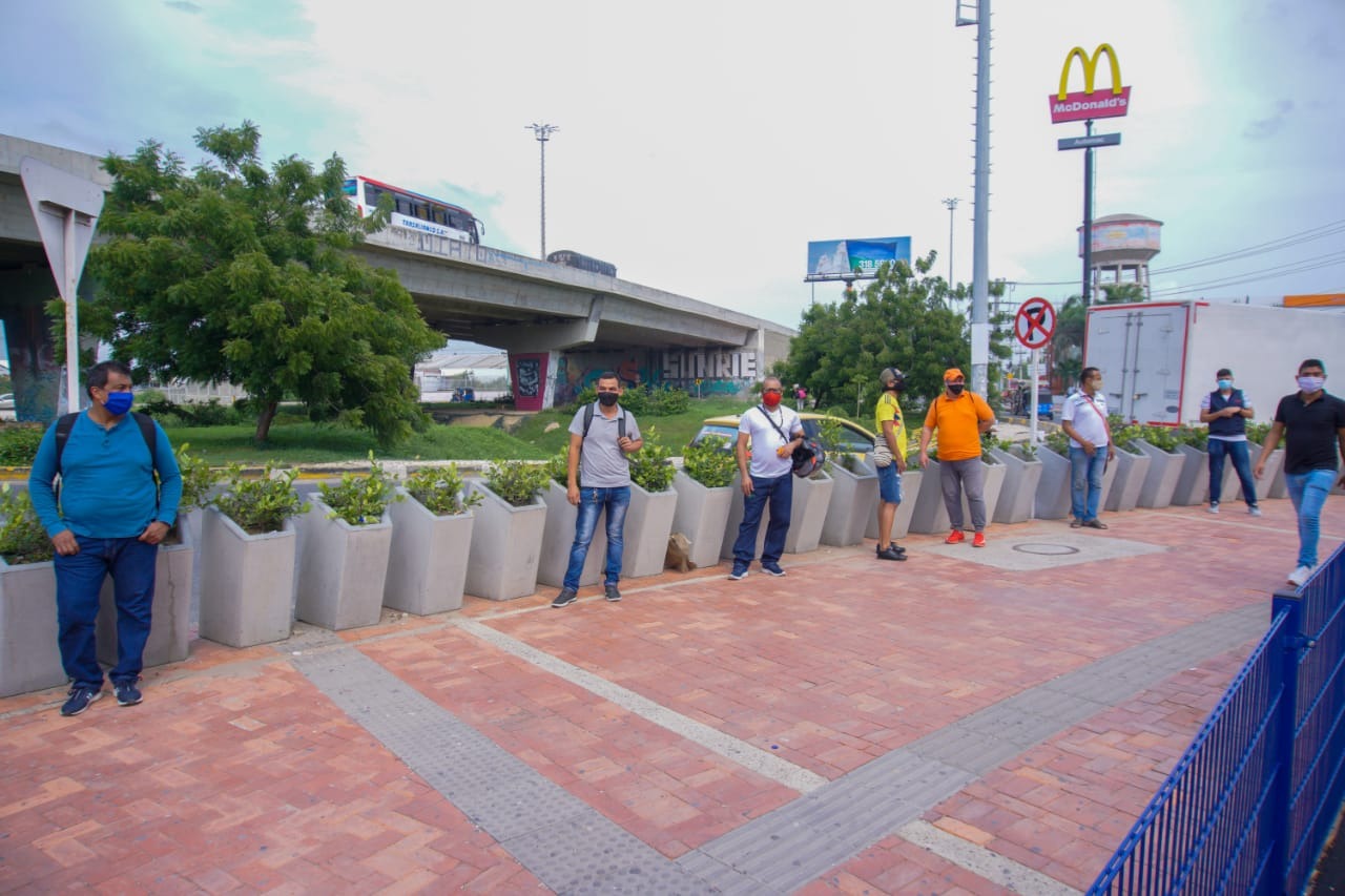 Hombres guardando el distanciamiento social en la fila a las afueras del centro comercial Plaza del Sol.