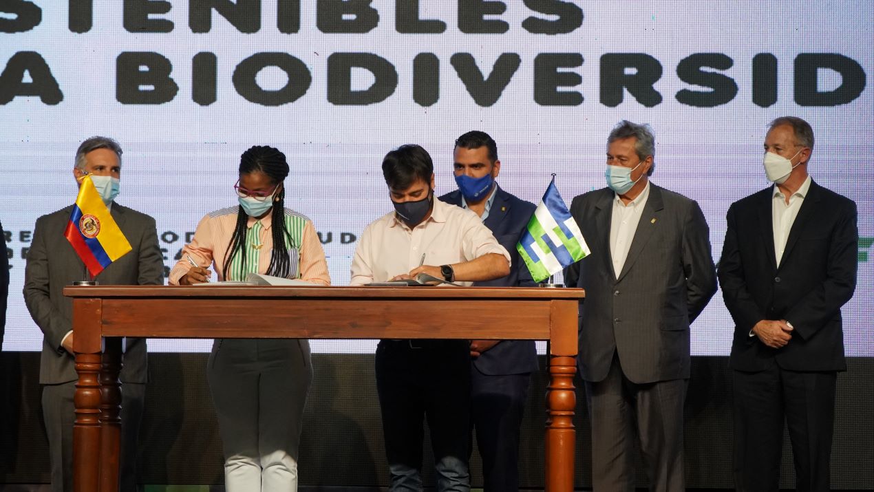 Los alcaldes de Timbiquí, Neyla Yadira Amú Venté; y el alcalde de Barranquilla, Jaime Pumarejo, firman un documento en el foro de Biodiverciudad.