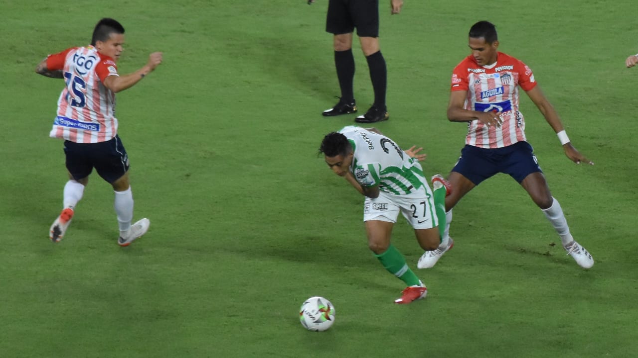 Sebastián Gómez intentando eludir la marca de Homer Martínez y Walmer Pacheco.