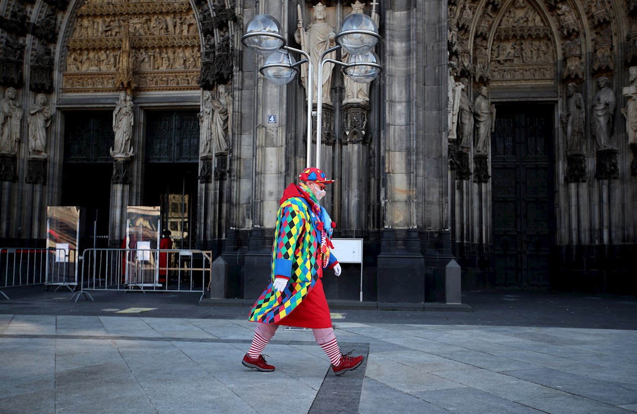 Un juerguista disfrazado se ve en el 'Alter Markt' donde normalmente miles de juerguistas vestidos con trajes de carnaval celebrarían el inicio del carnaval callejero en Colonia, Alemania.