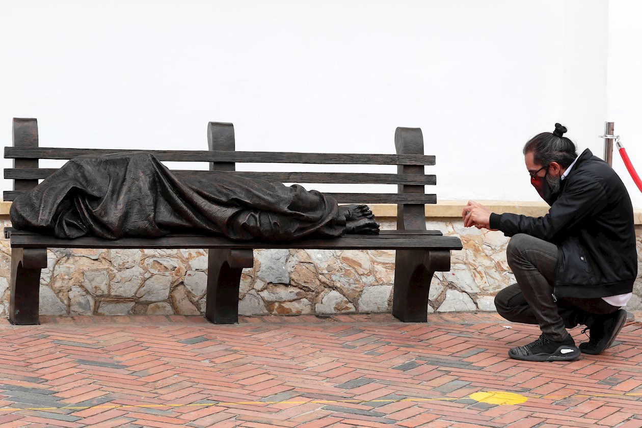 Un hombre toma hoy, viernes una foto de la estatua "Jesús habitante de calle" en Bogotá (Colombia). 